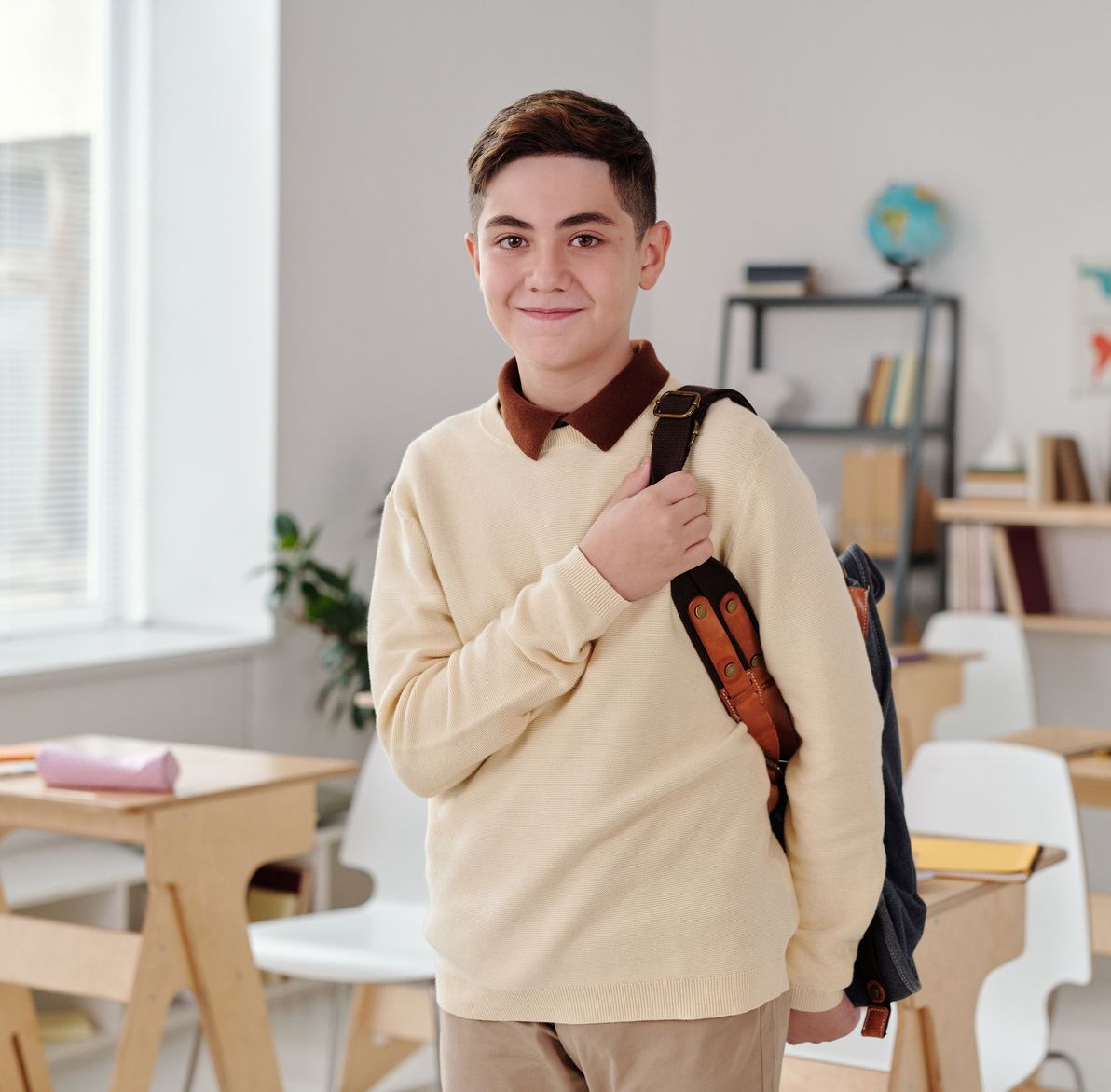 A smiling student studying English on a laptop